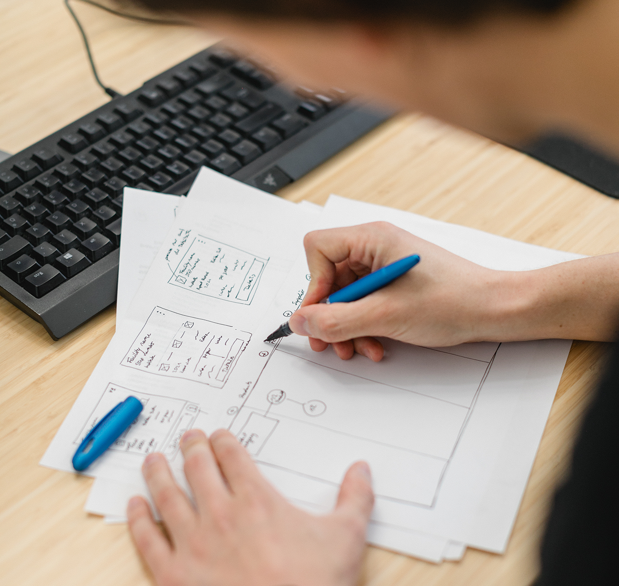 Wireframes Enterprise UX Nils Jürgens skizziert Wireframes auf einem Blatt Papier mit einem Fineliner für Enterprise UX.
